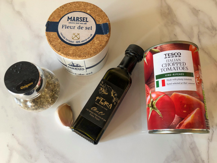 ingredients for the pizza sauce recipe - salt, oregano, olive oil, garlic and a tin of tomatoes